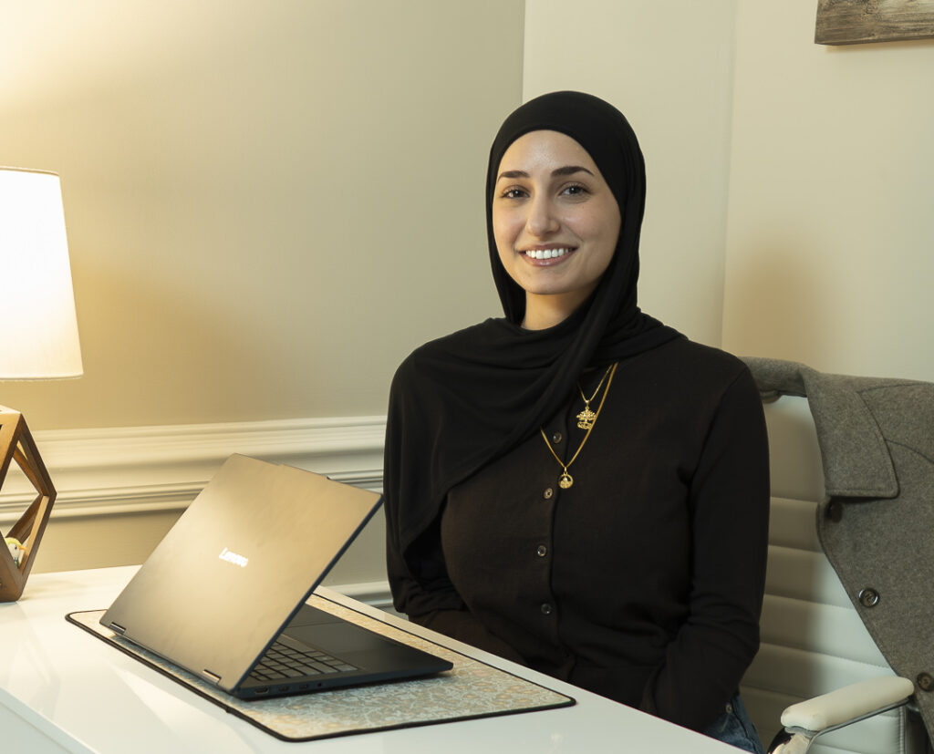 Receptionist smiling professionally at desk with laptop